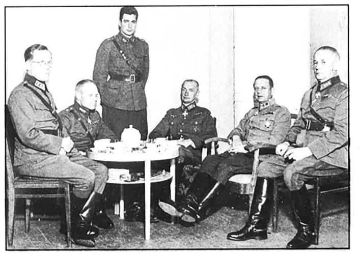 Kenraali Erfurt kävi kesällä 1944 Harlun pappilassa luovuttamassa Saksan rautaristin kenraalimajuri Martolalle. Seisomassa adjutantti van der Pals, hänestä oikealle Erfurt ja Martola. Van der Palsin kotialbumi