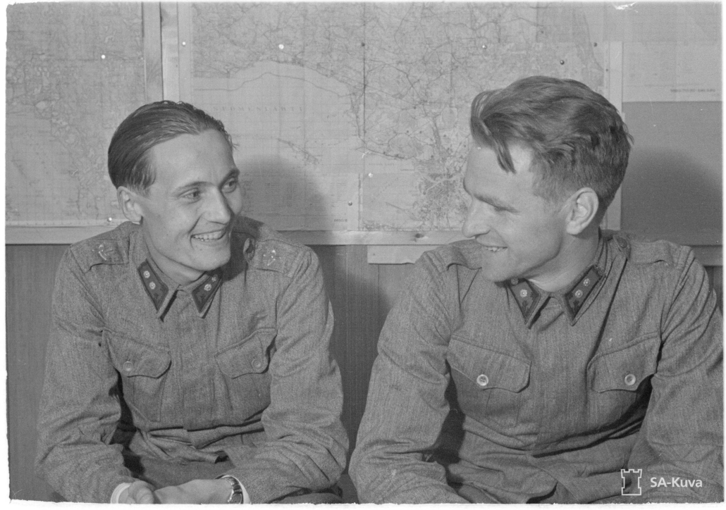 Mustavalkoisessa kuvassa kaksi hymyilevää luutnanttia.