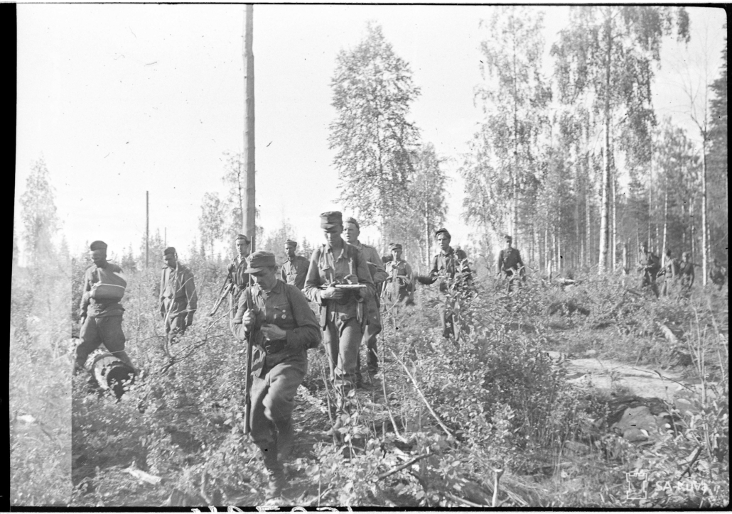 Mustavalkoisessa kuvassa sotilaita metsässä