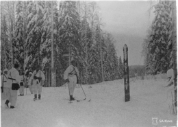 Mustavalkoisessa kuvassa lumipukuisia sotilaita