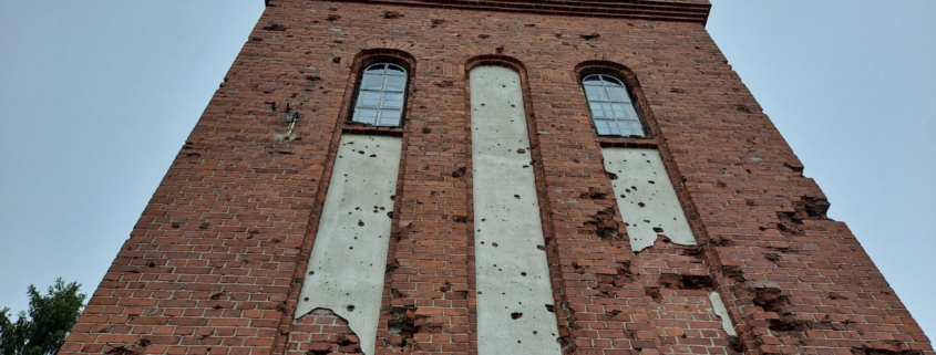 Simolan vesitorni seisoo vankasti paikallaan, vaikka kantaa sirpaleiden vaurioita.