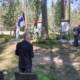 kuvassa ihmisiä ja lippuja maanpuolustusjuhlassa.