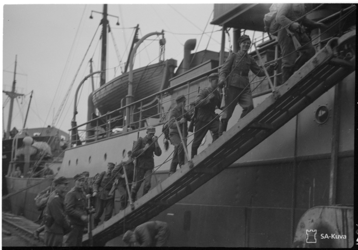 Mustavalkoisessa kuvassa sotilaita nousemassa laivaan.