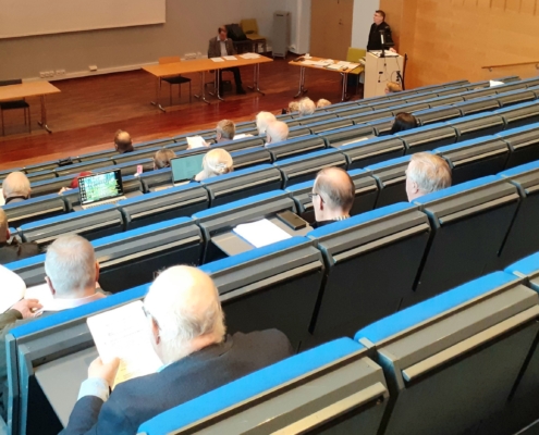 Kuvassa kokousväkeä auditoriossa.