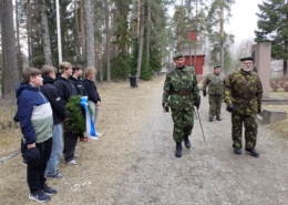 Kuvassa kunniavartio saapuu sankarihautausmaalle yleisön seuratessa.