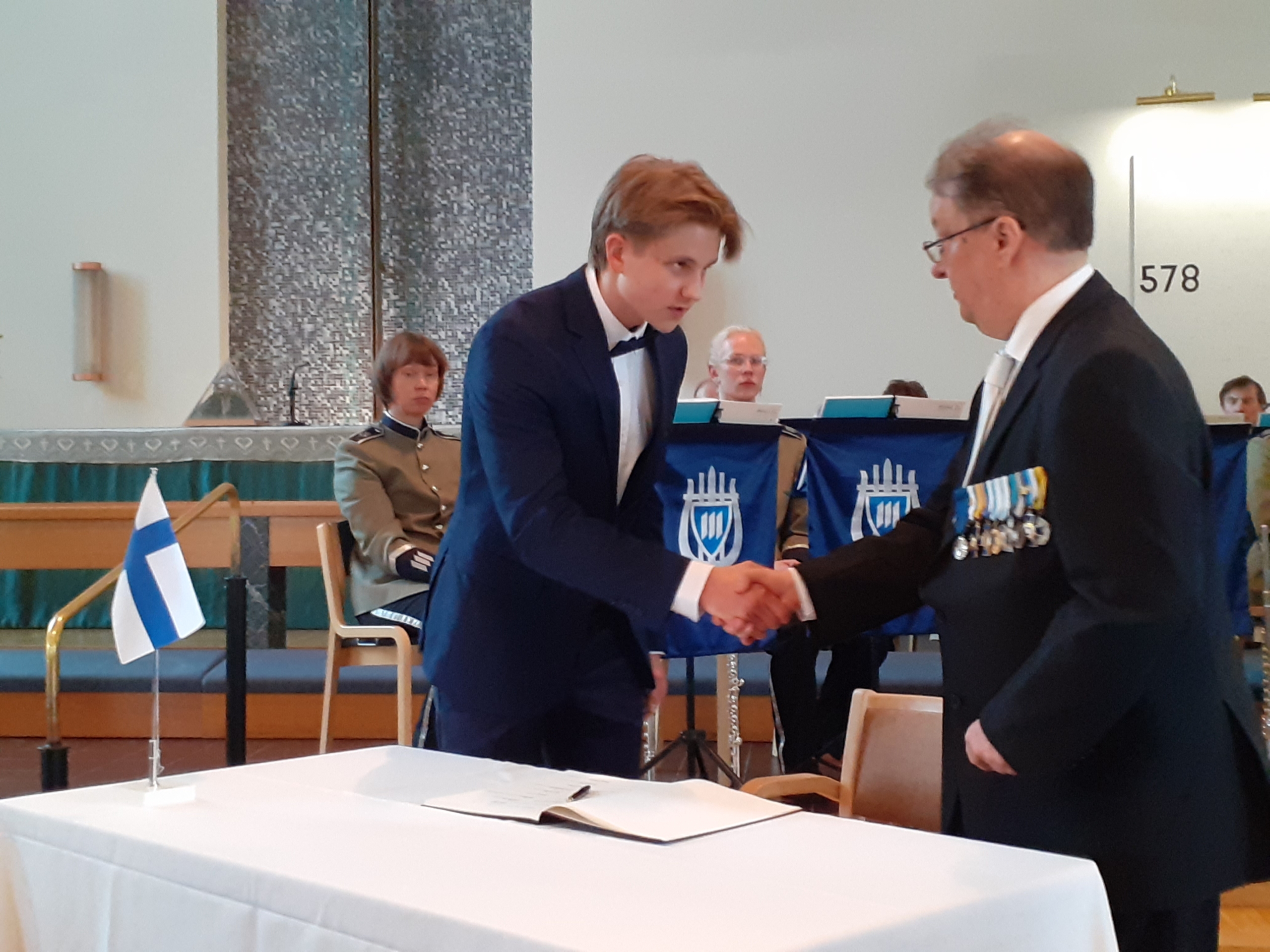 kuvassa kaksi mieshenkilöä kättelee.