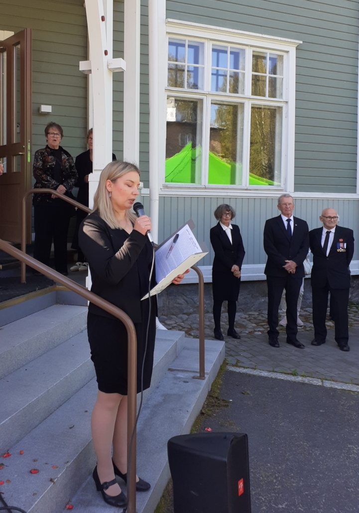 Kuvassa nainen puhumassa mikrofoniin.