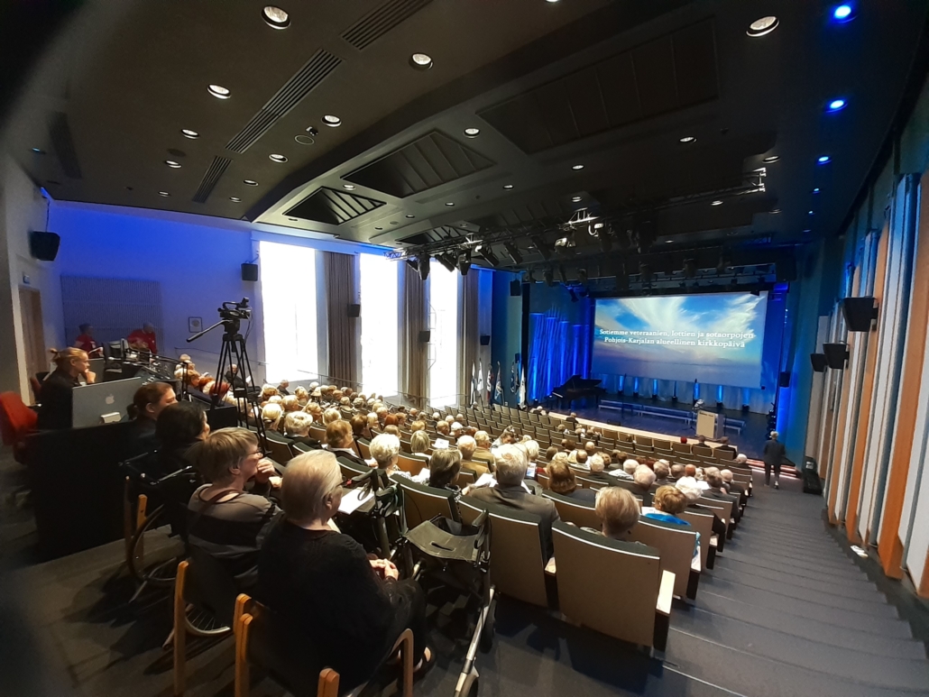 Kuvassa juhlaväkeä auditoriossa.