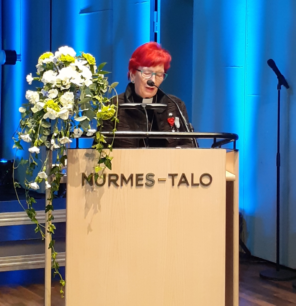 Kuvassa naishenkilö puhujanpöntössä.