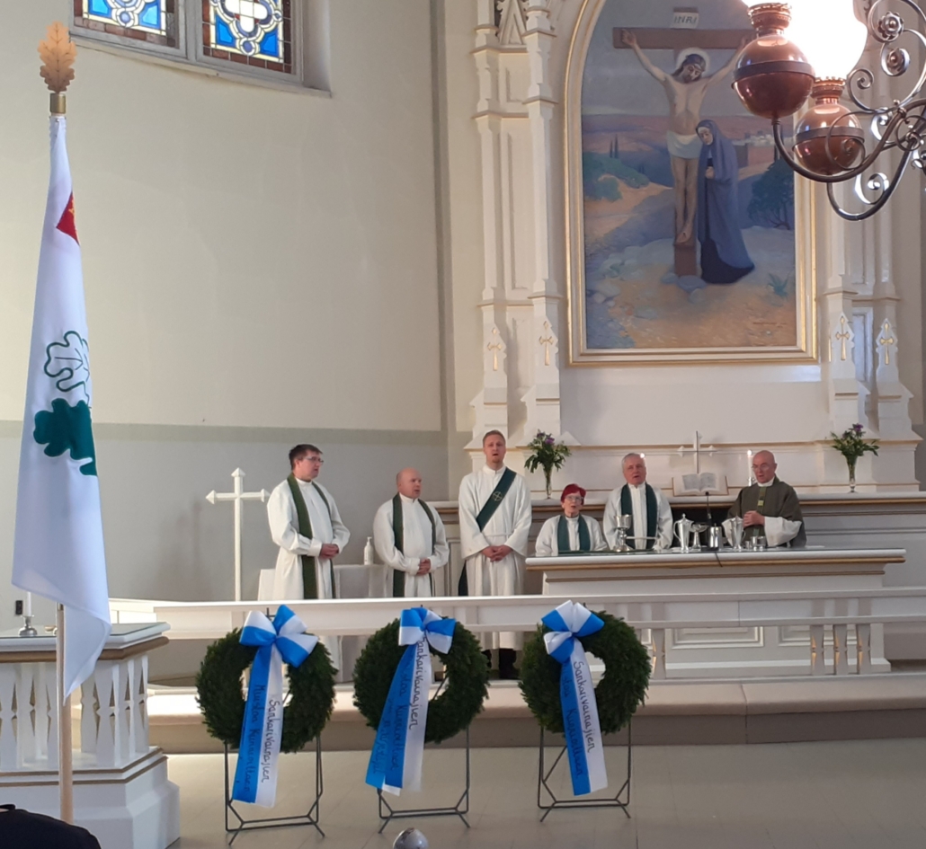 Kuvassa kuusi pappia alttarilla ehtoollisastioiden kanssa.