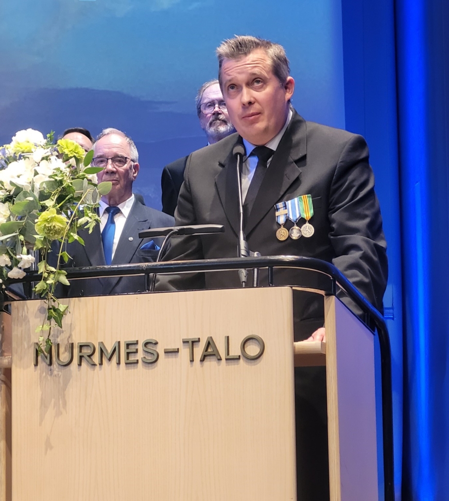 Kuvassa mieshenkilö puhujanpöntössä.