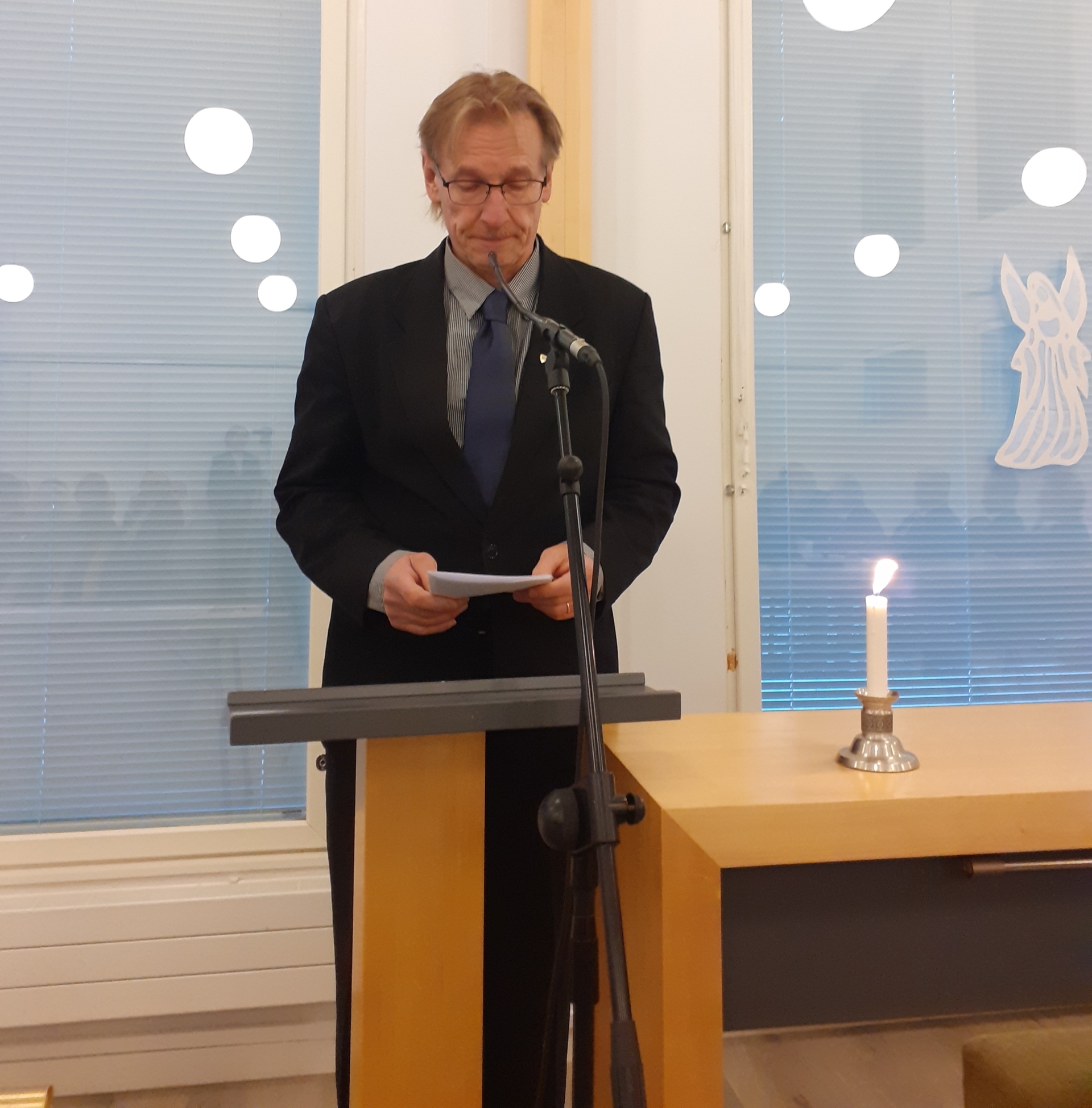 Kuvassa mieshenkilö pitämässä puhetta.