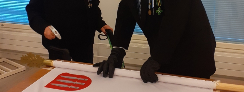 Kuvassa ilmavalvontalotta naulaamassa lippua.