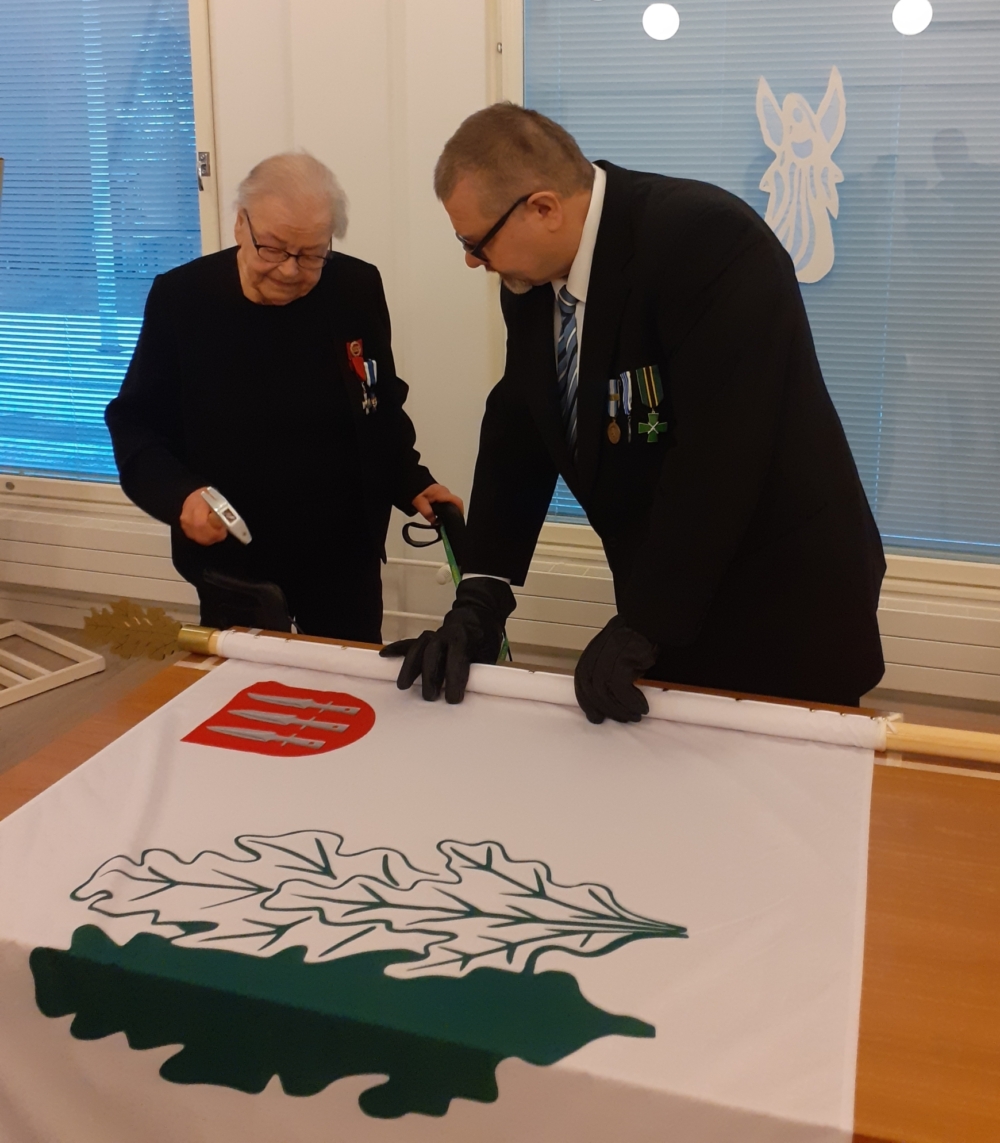 Kuvassa ilmavalvontalotta naulaamassa lippua.