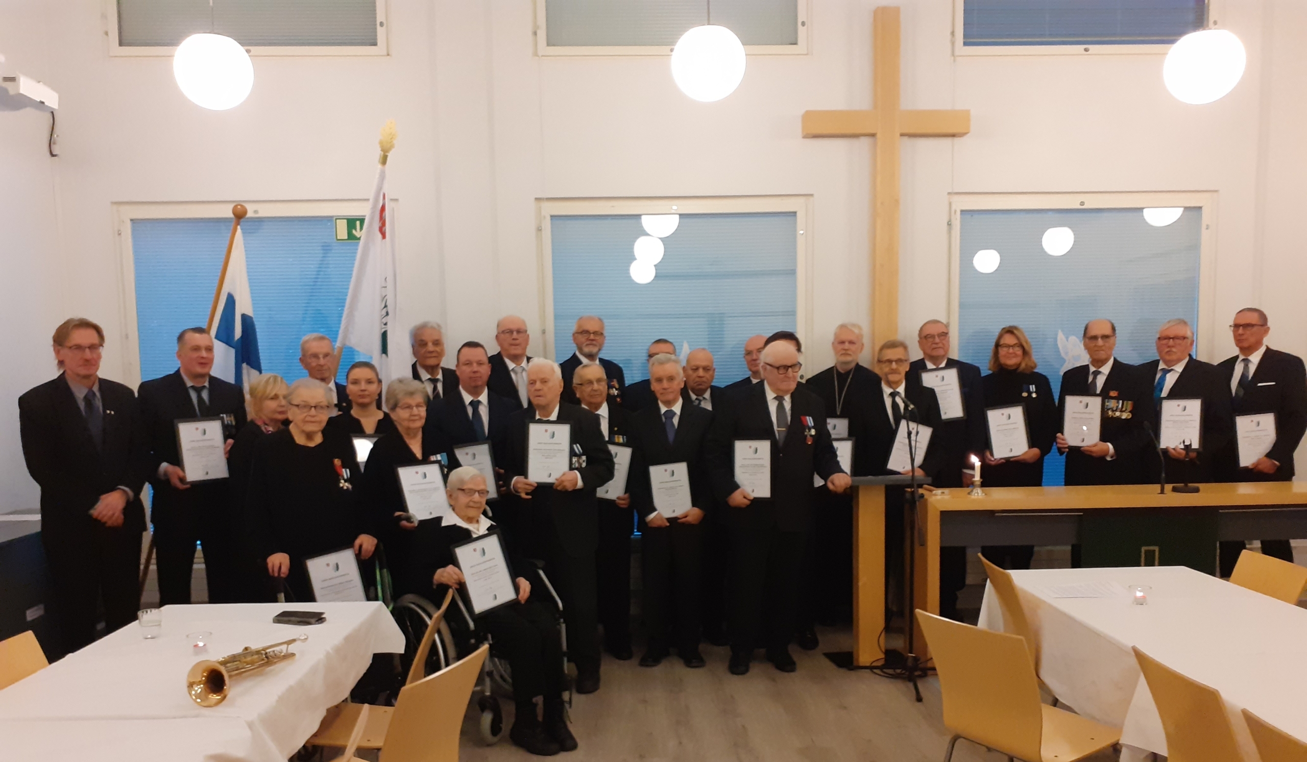 Ryhmäkuva ihmisistä, jotka pitelevät lipun naulaustodistuksia.