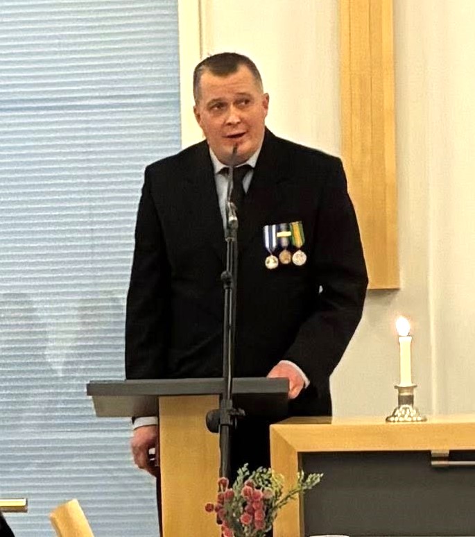 Kuvassa mieshenkilö pitämässä puhetta.