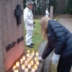 Kuvassa lasketaan kynttilä sankarihaudan muistomerkille. Taustalla kunniavartio.