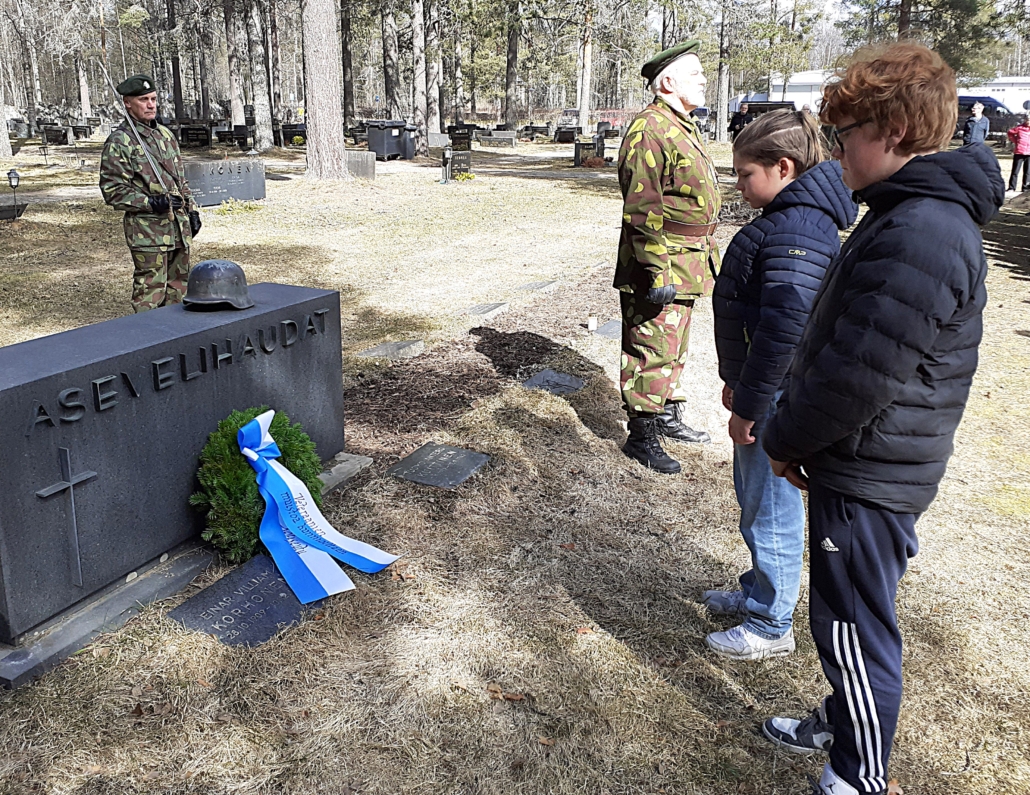 Kuvassa seppeleenlaskeminen, taustalla kunniavartio.