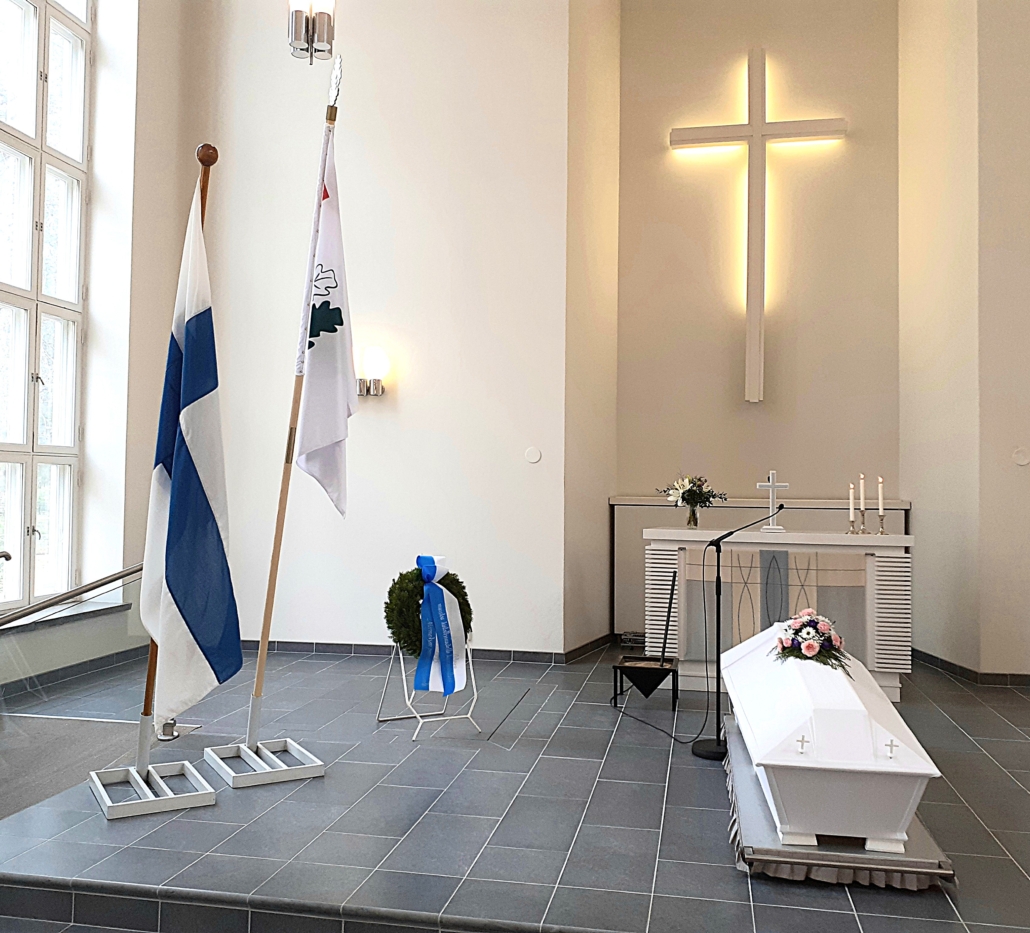 Kuvassa arkku, liput ja seppele siunauskappelin alttarilla.