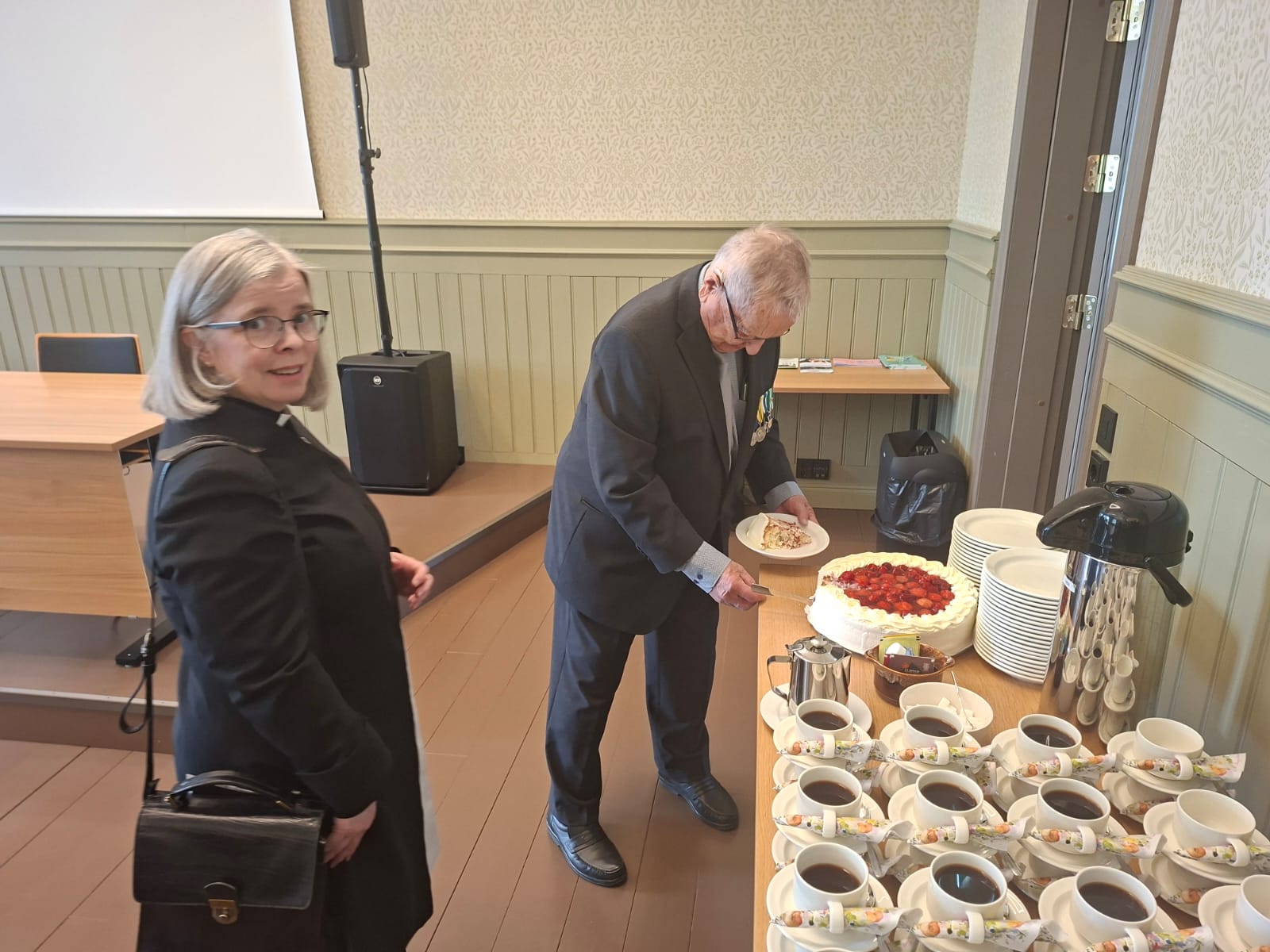 Kuvassa ihmisiä tarjoilupöydän äärellä.