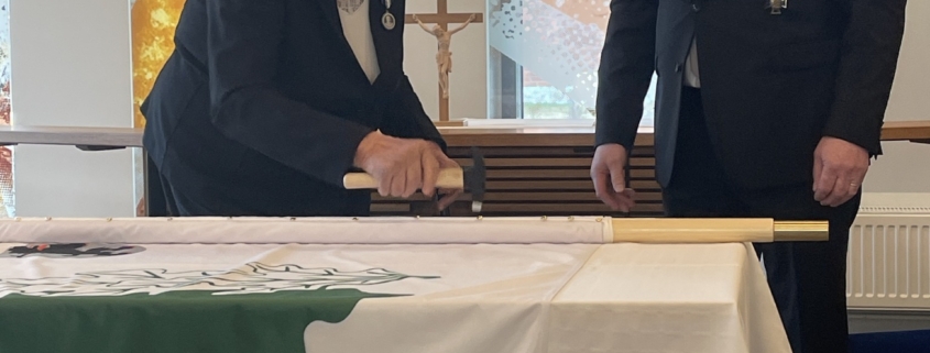 Kuvassa lipun naulaaja ja lippu-upseeri.